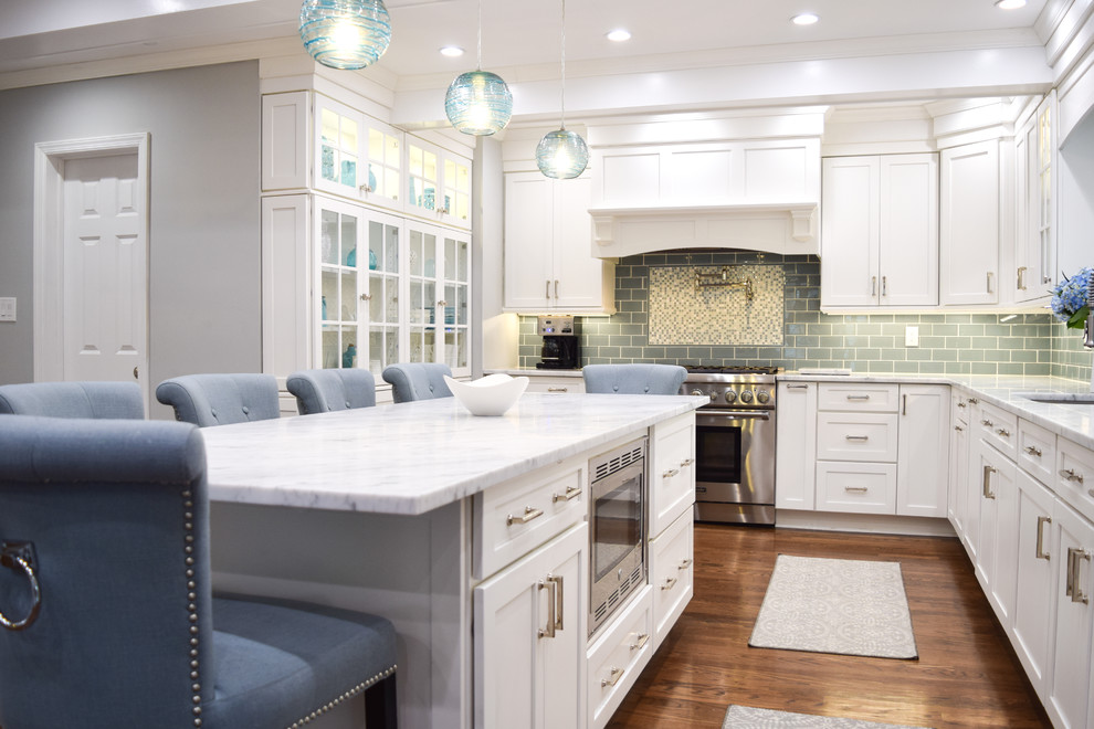 Inspiration for a large beach style l-shaped kitchen/diner in New York with a submerged sink, shaker cabinets, white cabinets, marble worktops, blue splashback, metro tiled splashback, stainless steel appliances, medium hardwood flooring and an island.