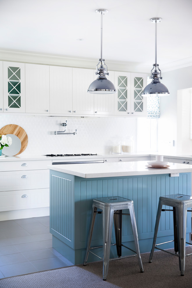 Mid-sized eat-in kitchen photo in Sydney with raised-panel cabinets, white cabinets, white backsplash, stainless steel appliances and an island