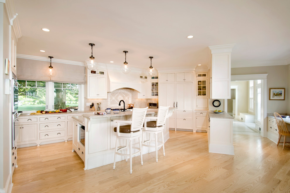 Photo of a traditional kitchen in Boston with recessed-panel cabinets, white cabinets, integrated appliances and beige splashback.