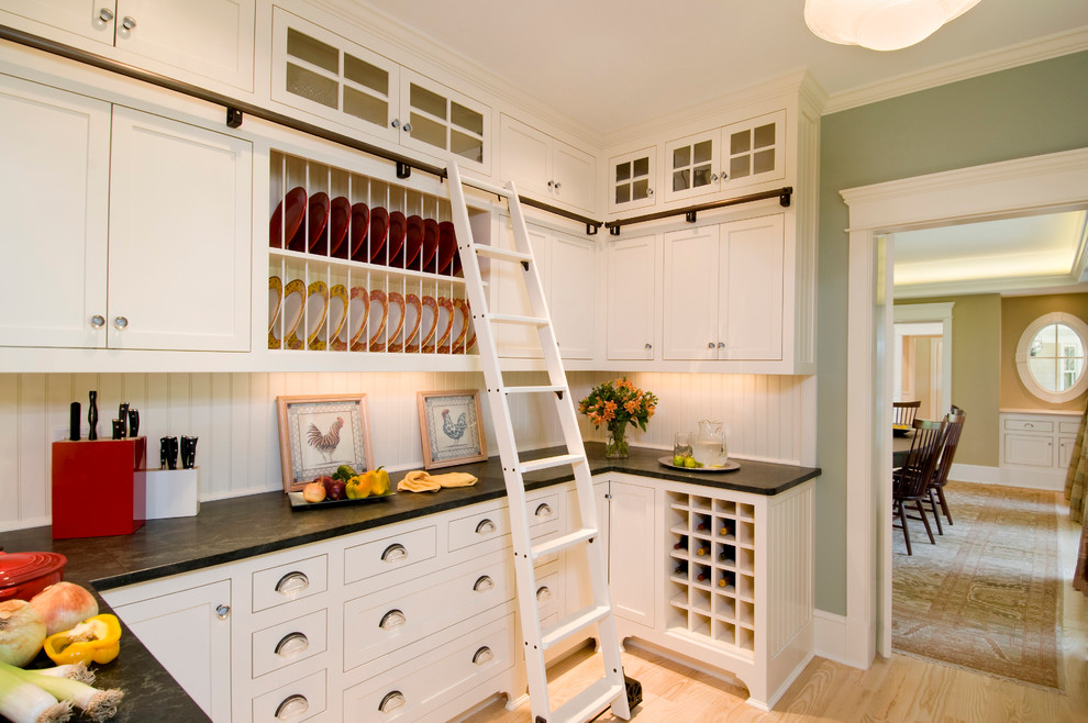 Example of a classic kitchen design in Boston with recessed-panel cabinets, white cabinets and white backsplash