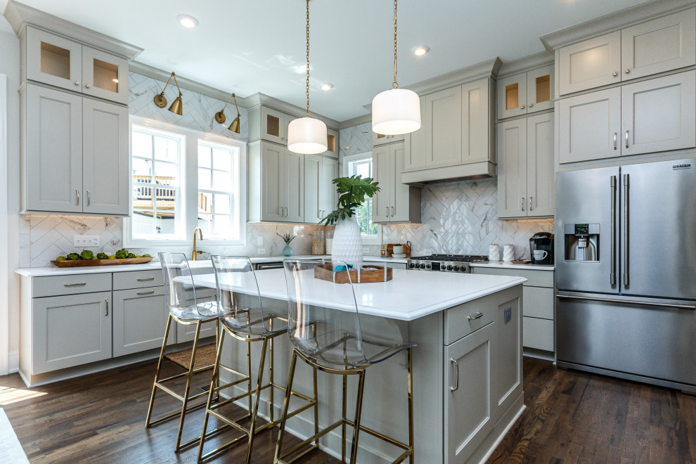 Kitchen - transitional l-shaped dark wood floor and brown floor kitchen idea in Other with a farmhouse sink, recessed-panel cabinets, gray cabinets, white backsplash, stainless steel appliances, an island and white countertops