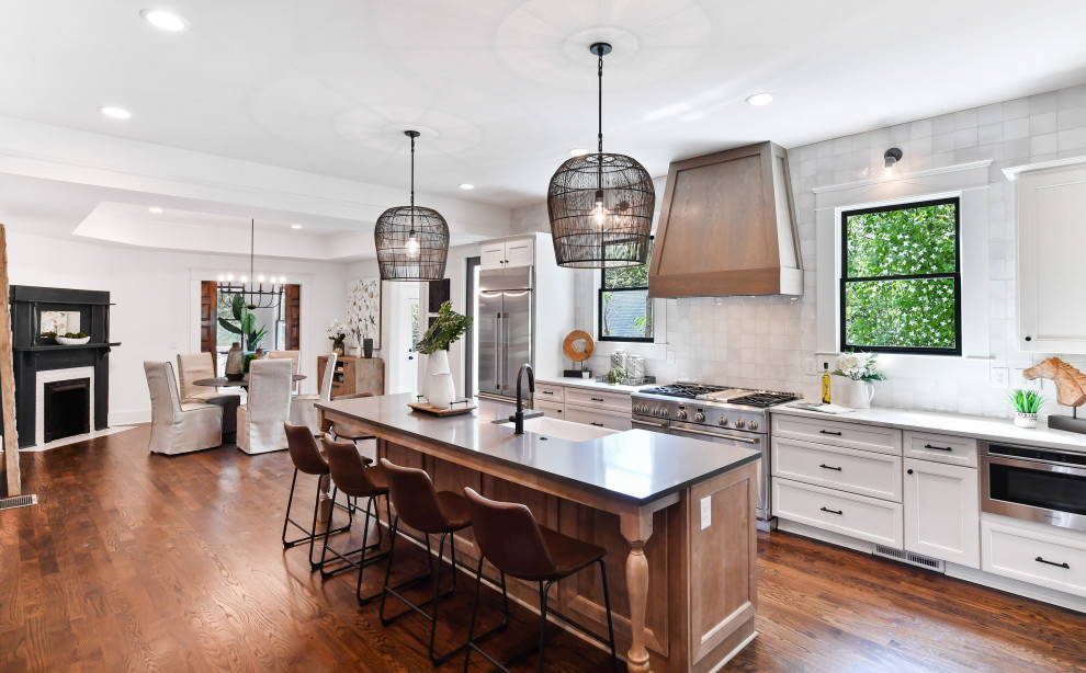 アトランタにある高級な広いトラディショナルスタイルのおしゃれなII型キッチン (エプロンフロントシンク、クオーツストーンカウンター、白いキッチンパネル、シルバーの調理設備、濃色無垢フローリング、茶色い床) の写真