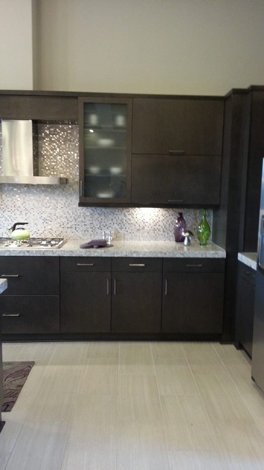 Immagine di una cucina contemporanea con lavello sottopiano, ante lisce, ante in legno bruno, top in quarzo composito, paraspruzzi grigio e elettrodomestici in acciaio inossidabile