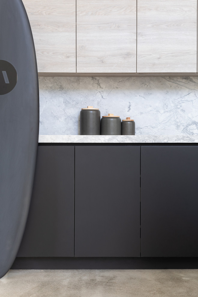 Idee per una piccola cucina moderna con lavello a vasca singola, ante lisce, ante nere, paraspruzzi grigio, elettrodomestici neri, pavimento in cemento, pavimento grigio, top grigio e soffitto a volta