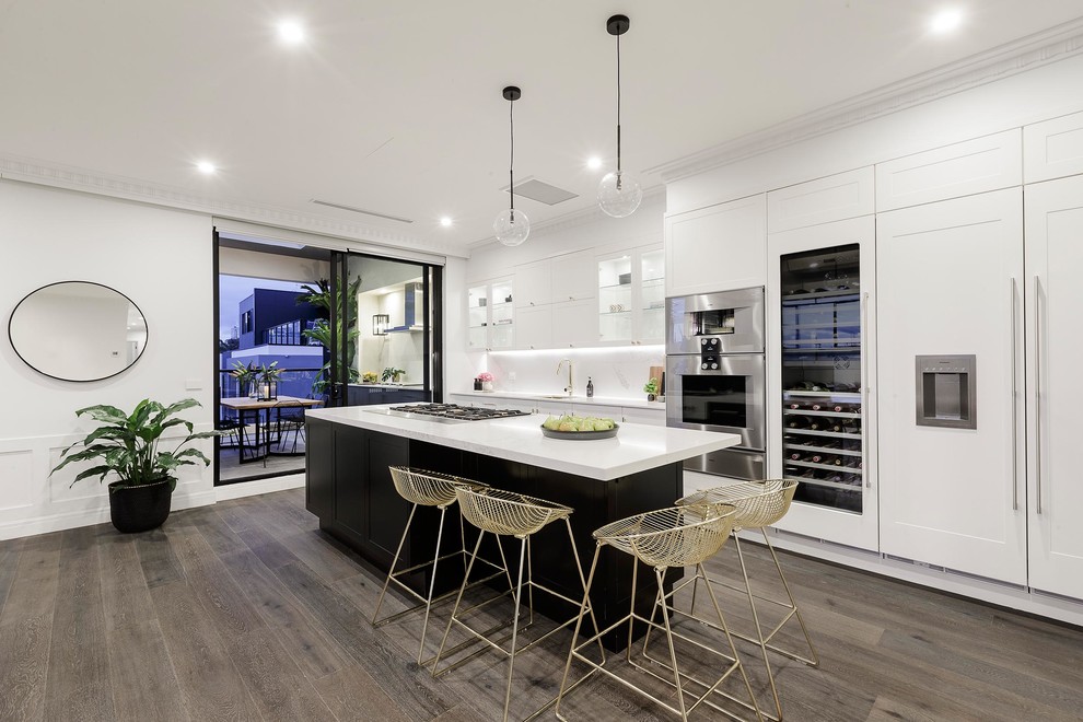 Zweizeilige Moderne Küche mit Schrankfronten im Shaker-Stil, weißen Schränken, Küchenrückwand in Weiß, Elektrogeräten mit Frontblende, dunklem Holzboden und Kücheninsel in Melbourne