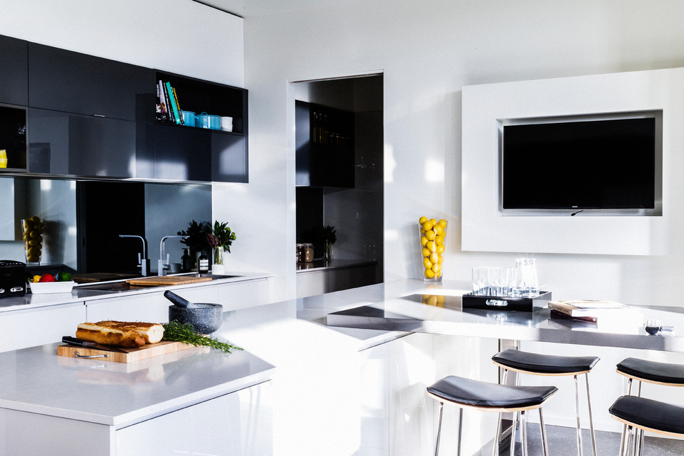 Idéer för att renovera ett funkis linjärt kök och matrum, med vita skåp, spegel som stänkskydd, betonggolv och en köksö