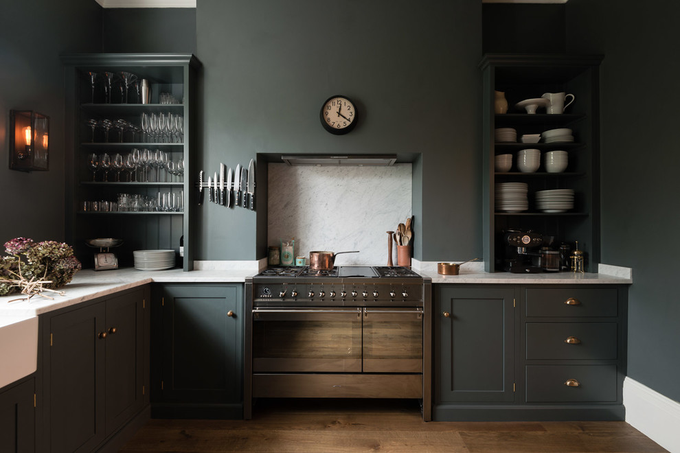 Klassische Küche mit Landhausspüle, offenen Schränken, grauen Schränken, Küchenrückwand in Weiß, Küchengeräten aus Edelstahl und braunem Holzboden in London