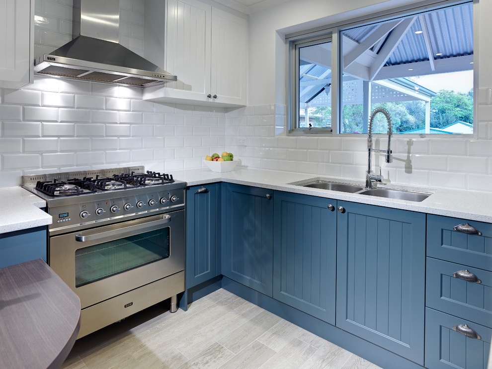 Enclosed kitchen - small traditional u-shaped enclosed kitchen idea in Other with an undermount sink, shaker cabinets, blue cabinets, white backsplash, subway tile backsplash and stainless steel appliances