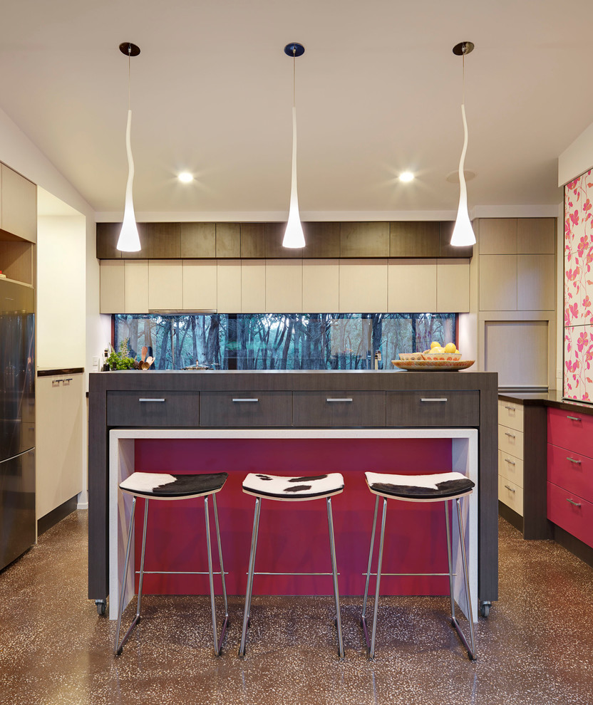 メルボルンにある高級な中くらいなコンテンポラリースタイルのおしゃれなキッチン (ダブルシンク、フラットパネル扉のキャビネット、赤いキャビネット、クオーツストーンカウンター、マルチカラーのキッチンパネル、ガラス板のキッチンパネル、シルバーの調理設備、コンクリートの床) の写真