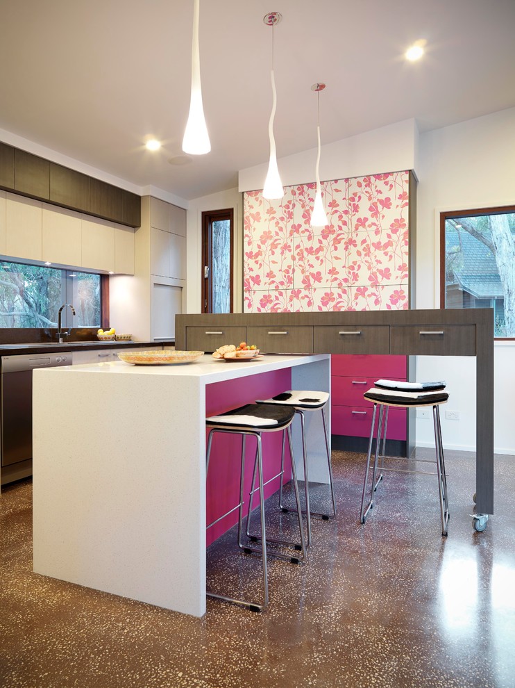 Design ideas for a medium sized world-inspired u-shaped kitchen/diner in Melbourne with a double-bowl sink, flat-panel cabinets, red cabinets, engineered stone countertops, multi-coloured splashback, glass sheet splashback, stainless steel appliances and concrete flooring.