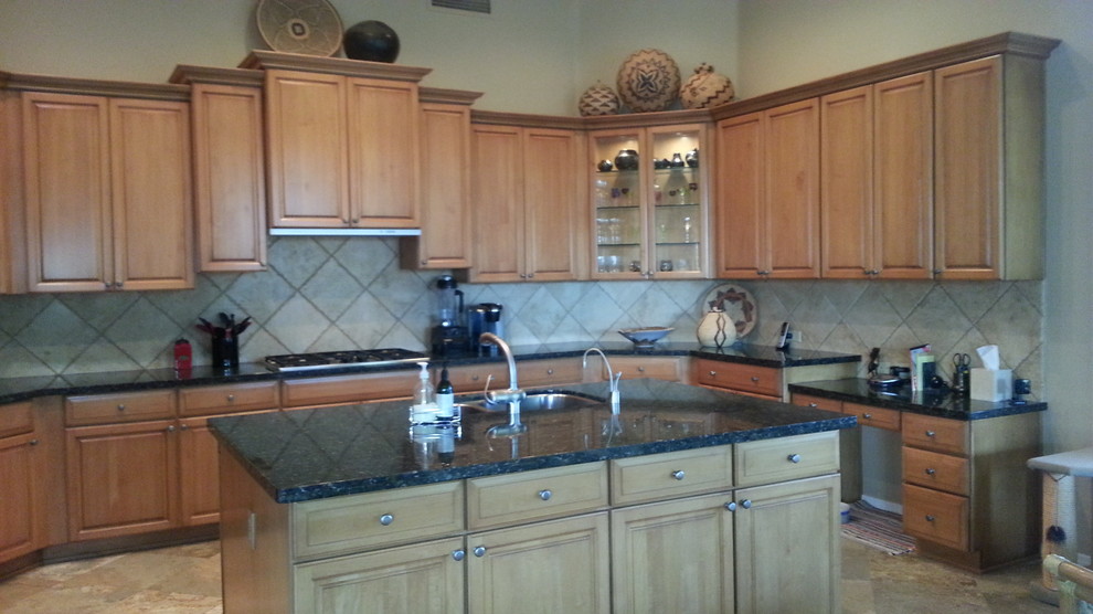 Example of a large southwest u-shaped travertine floor kitchen design in Phoenix with an undermount sink, light wood cabinets, granite countertops, porcelain backsplash, stainless steel appliances and an island