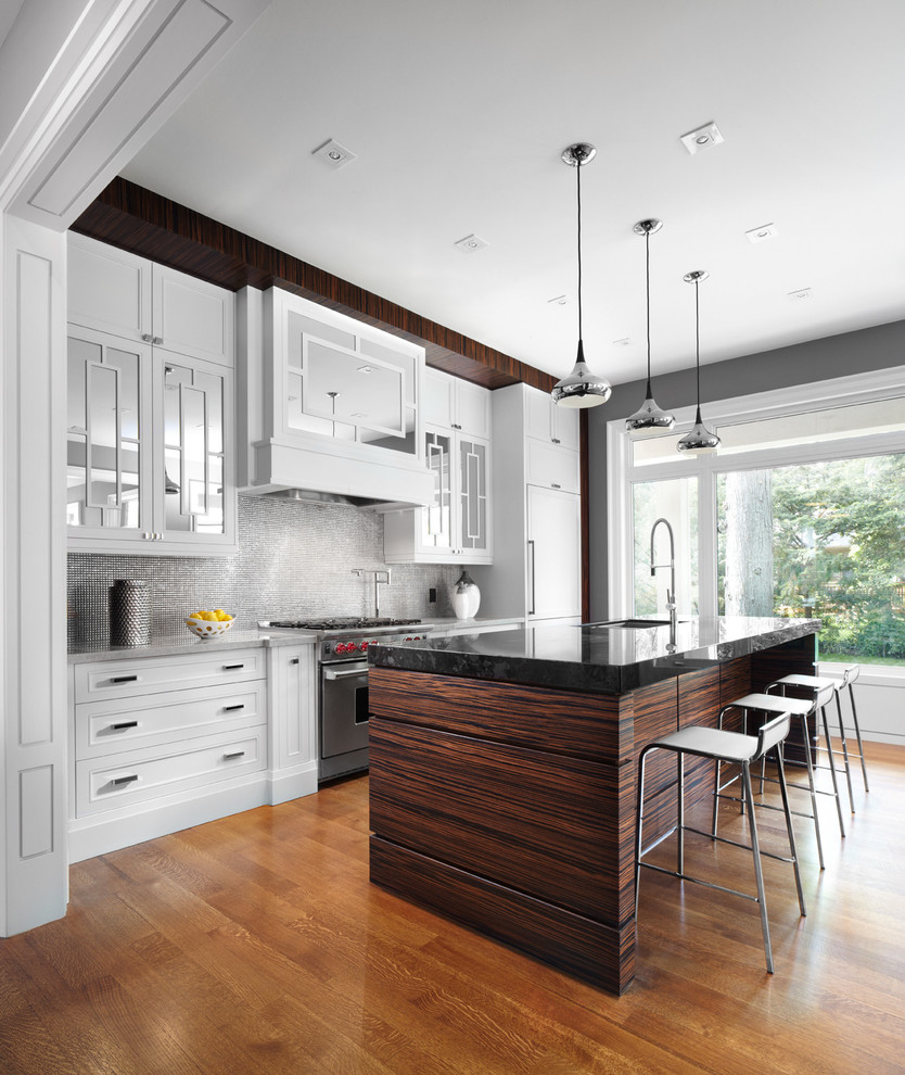 Example of a trendy galley kitchen design in Toronto with recessed-panel cabinets, granite countertops, metallic backsplash, metal backsplash and paneled appliances