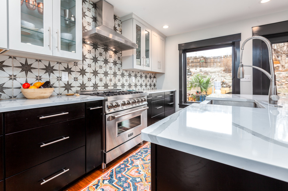 Medium sized traditional galley kitchen/diner in Denver with a belfast sink, shaker cabinets, white cabinets, quartz worktops, multi-coloured splashback, stainless steel appliances, bamboo flooring, an island, brown floors and white worktops.