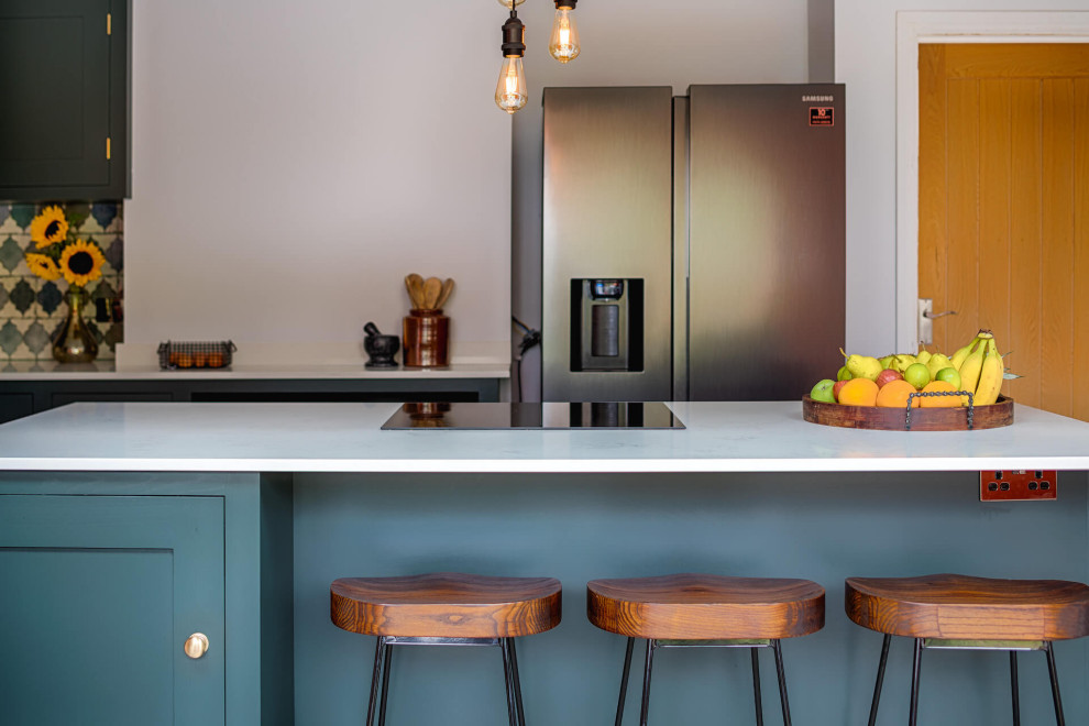 Inspiration for a medium sized contemporary l-shaped kitchen/diner in Other with a built-in sink, shaker cabinets, green cabinets, quartz worktops, green splashback, ceramic splashback, laminate floors, an island and white worktops.