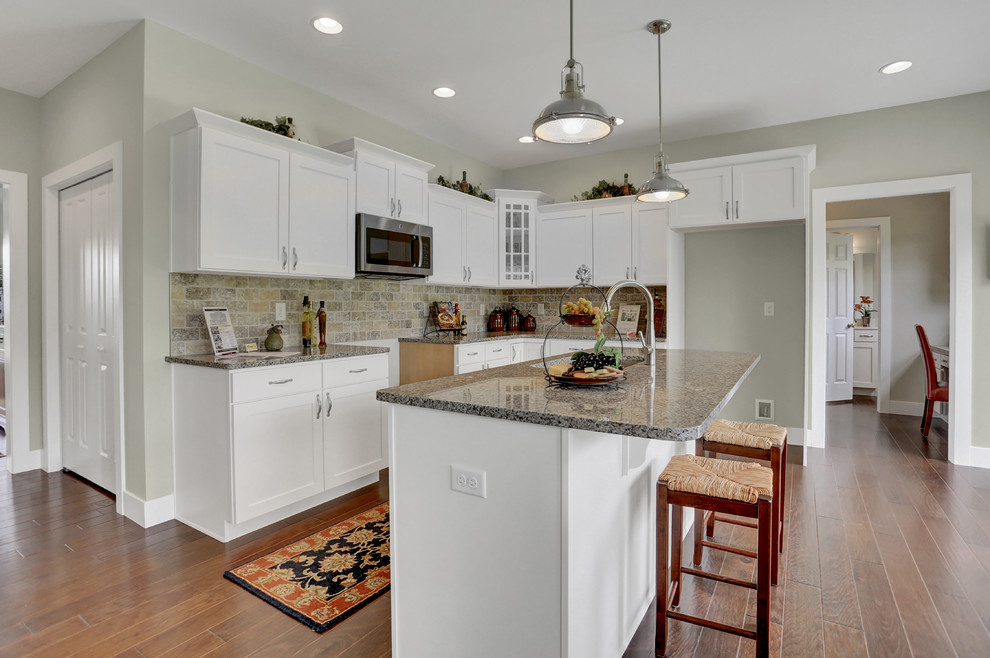 Example of a large arts and crafts dark wood floor eat-in kitchen design in Other with a double-bowl sink, white cabinets, gray backsplash, brick backsplash, stainless steel appliances and an island