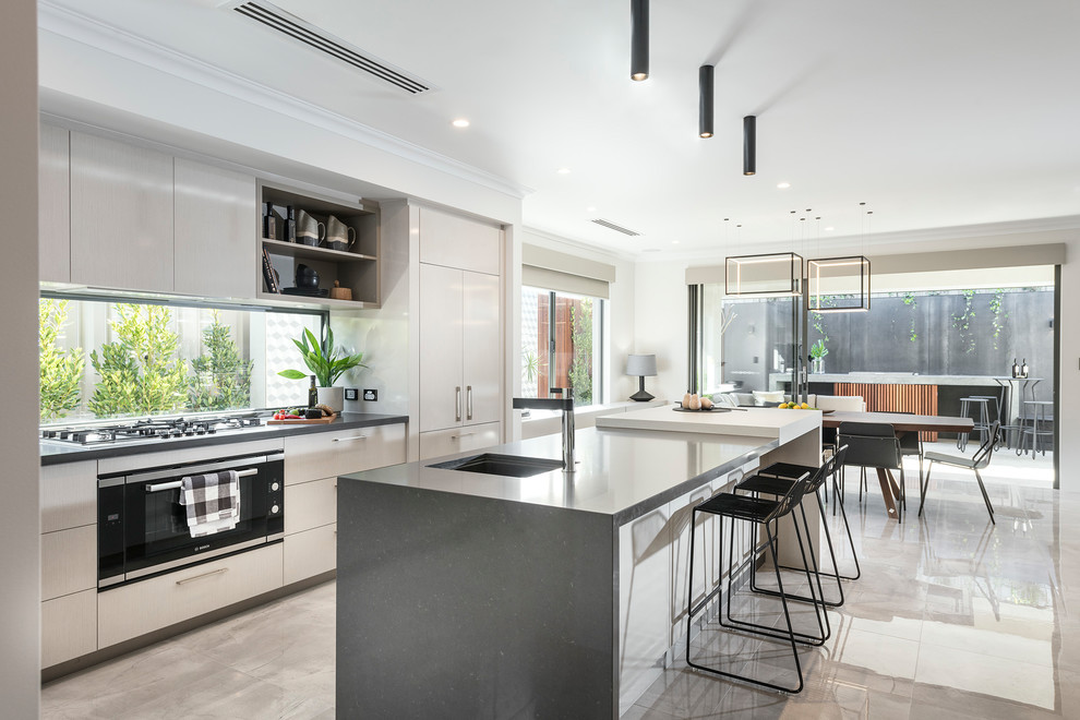 Zweizeilige Moderne Wohnküche mit Unterbauwaschbecken, flächenbündigen Schrankfronten, beigen Schränken, Rückwand-Fenster, schwarzen Elektrogeräten, Kücheninsel und beigem Boden in Perth