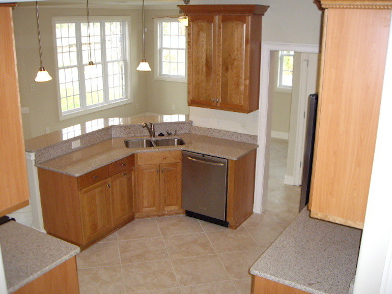 Foto di una piccola cucina design con lavello a doppia vasca, ante a filo, ante in legno scuro, top in granito, elettrodomestici in acciaio inossidabile e nessuna isola