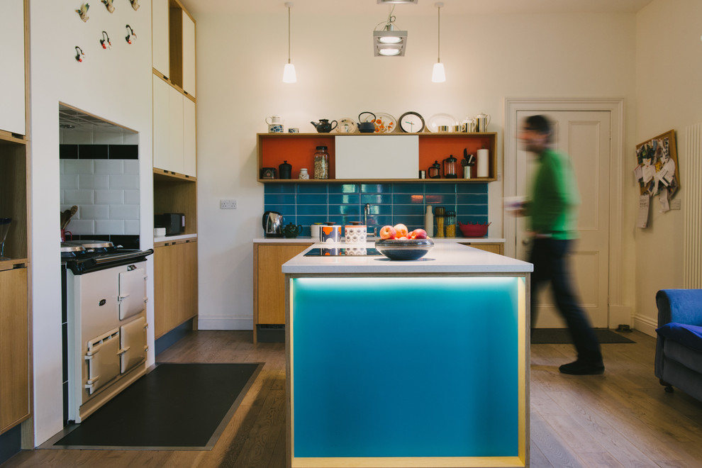 Photo of a large contemporary u-shaped open plan kitchen in Other with a built-in sink, flat-panel cabinets, light wood cabinets, quartz worktops, blue splashback, ceramic splashback, white appliances, light hardwood flooring and an island.