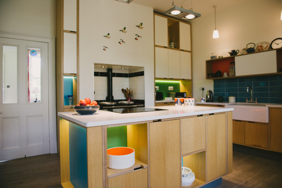 Photo of a large contemporary u-shaped open plan kitchen in Other with a built-in sink, flat-panel cabinets, light wood cabinets, quartz worktops, blue splashback, ceramic splashback, white appliances, light hardwood flooring and an island.