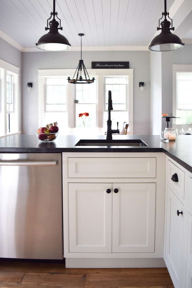 Photo of a small farmhouse u-shaped kitchen/diner in New York with a submerged sink, beaded cabinets, white cabinets, soapstone worktops, marble splashback, stainless steel appliances, medium hardwood flooring and a breakfast bar.