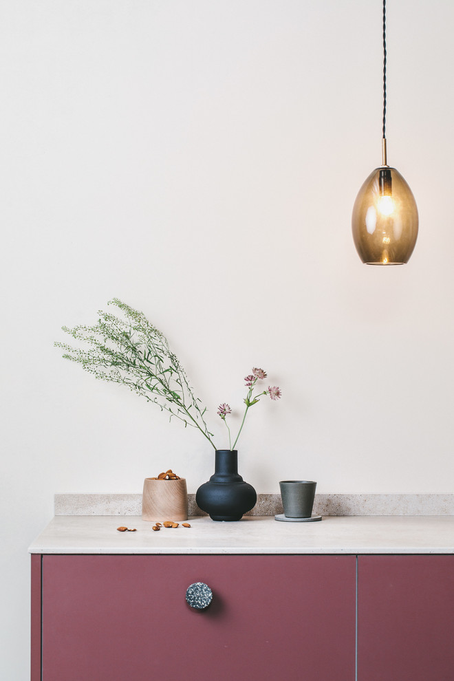 Exempel på ett litet modernt beige linjärt beige kök med öppen planlösning, med en nedsänkt diskho, släta luckor, röda skåp, bänkskiva i koppar, beige stänkskydd, stänkskydd i sten, integrerade vitvaror, målat trägolv och svart golv