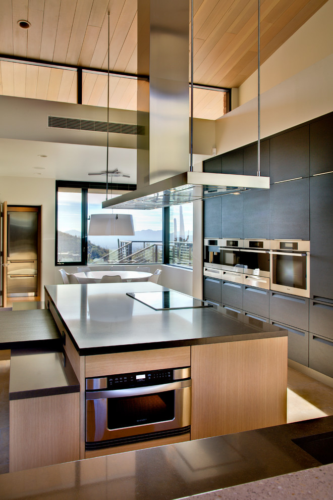 Immagine di un'ampia cucina minimalista con lavello sottopiano, ante lisce, ante nere, top in quarzo composito e elettrodomestici in acciaio inossidabile