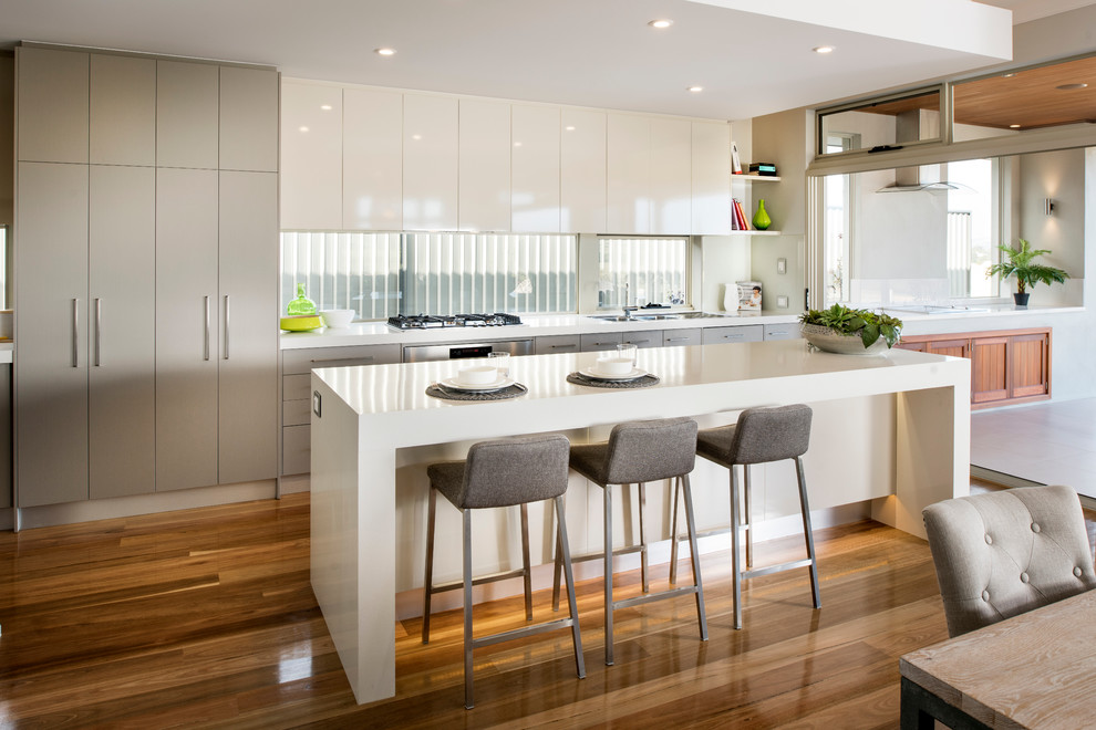 Zweizeilige, Große Moderne Wohnküche mit flächenbündigen Schrankfronten, weißen Schränken, braunem Holzboden, Kücheninsel, Doppelwaschbecken, Quarzit-Arbeitsplatte, Glasrückwand und Küchengeräten aus Edelstahl in Perth