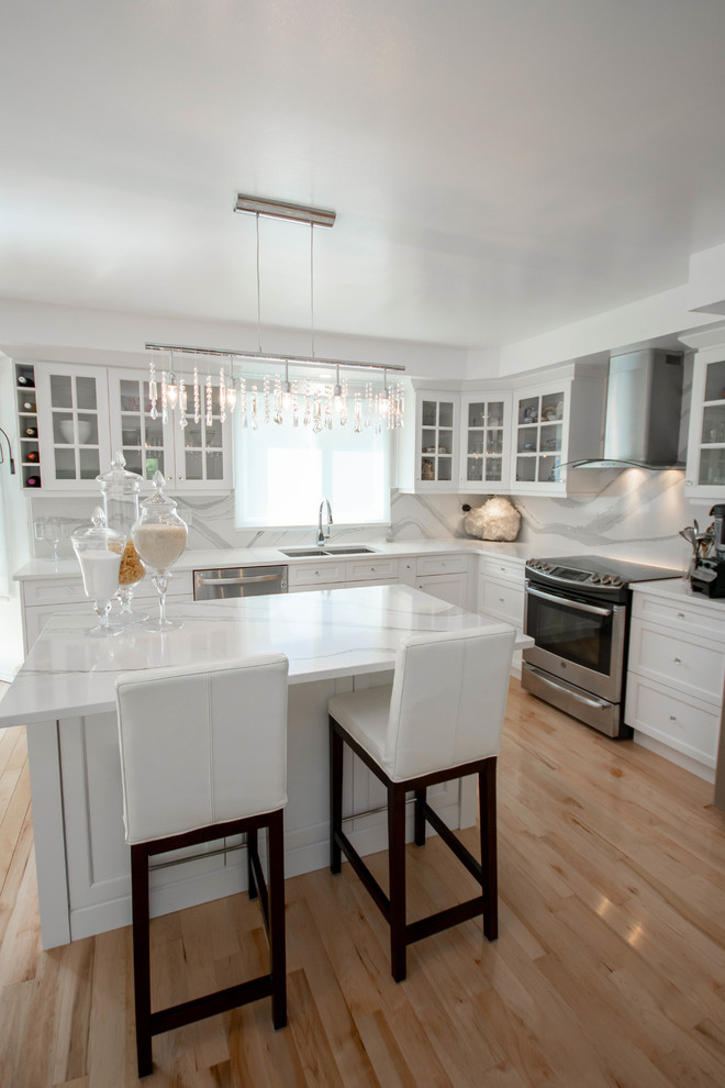 Bild på ett mellanstort vintage vit vitt kök, med en undermonterad diskho, skåp i shakerstil, vita skåp, bänkskiva i kvarts, vitt stänkskydd, rostfria vitvaror, ljust trägolv, en köksö och orange golv