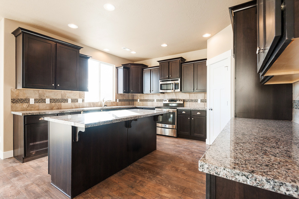 Photo of an u-shaped open plan kitchen in Salt Lake City with a submerged sink, shaker cabinets, dark wood cabinets, granite worktops, multi-coloured splashback, mosaic tiled splashback and stainless steel appliances.
