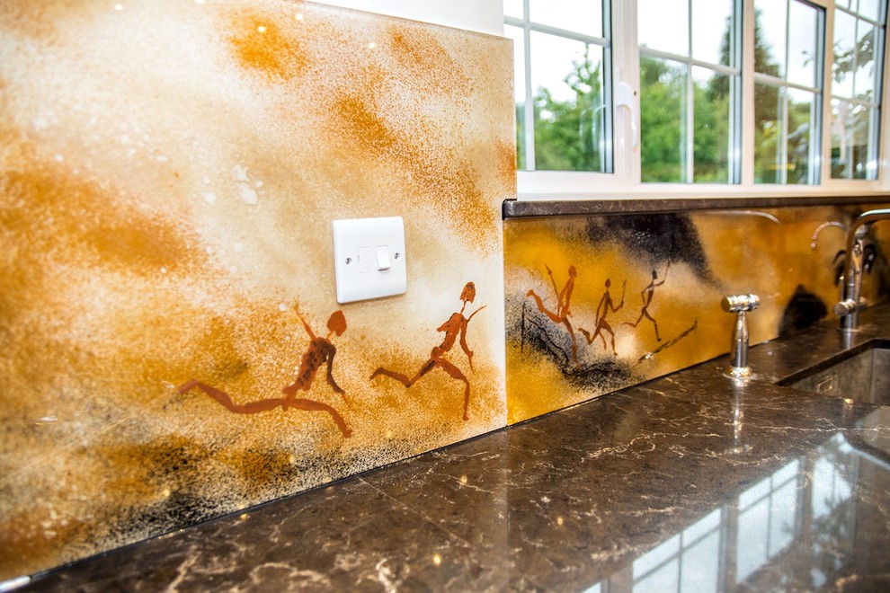 This is an example of a world-inspired kitchen in Hertfordshire with glass sheet splashback.