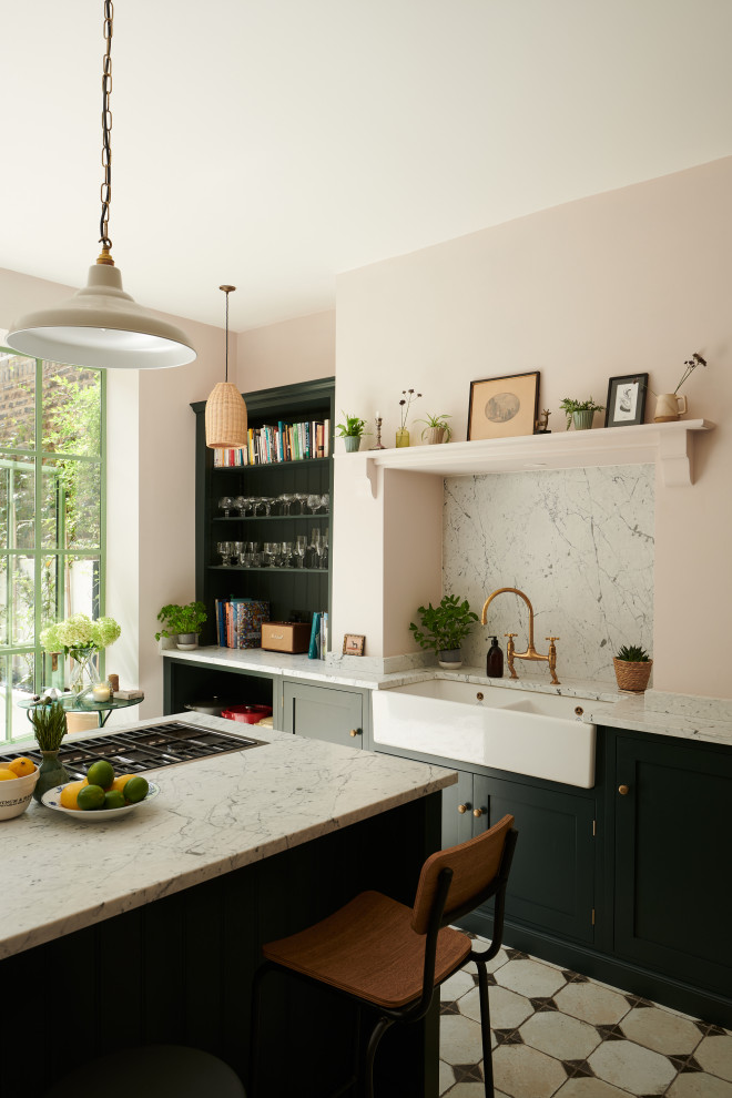 Inredning av ett medelhavsstil avskilt, mellanstort vit vitt kök, med en rustik diskho, skåp i shakerstil, gröna skåp, marmorbänkskiva, vitt stänkskydd, stänkskydd i marmor, rostfria vitvaror, klinkergolv i keramik, en köksö och gult golv
