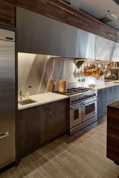 Inspiration for an expansive rustic single-wall enclosed kitchen in Chicago with a submerged sink, flat-panel cabinets, dark wood cabinets, engineered stone countertops, black splashback, metro tiled splashback, stainless steel appliances and multiple islands.