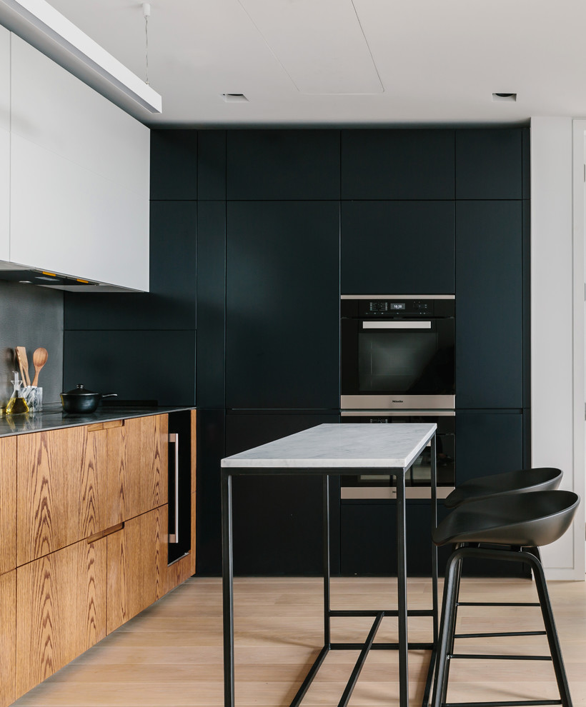 Photo of a small contemporary l-shaped kitchen/diner in London with an integrated sink, medium wood cabinets, stainless steel worktops, cement tile splashback, integrated appliances and a breakfast bar.