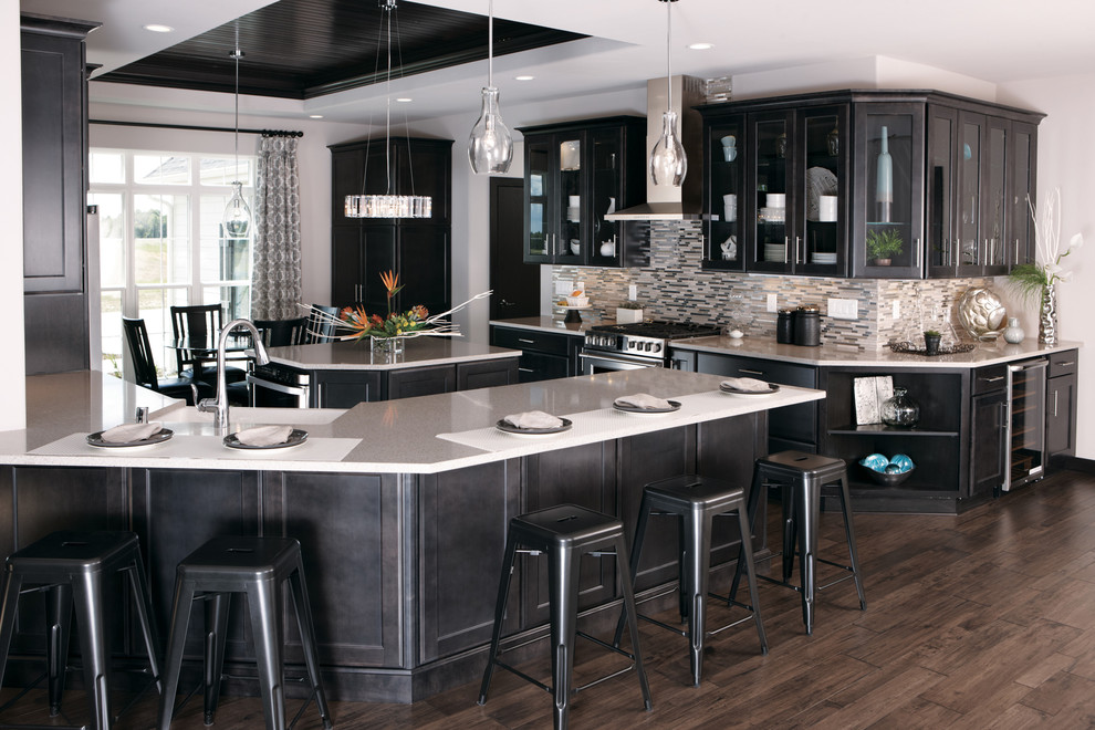 Inspiration for a mid-sized transitional u-shaped medium tone wood floor open concept kitchen remodel in Milwaukee with a farmhouse sink, glass-front cabinets, dark wood cabinets, quartz countertops, metallic backsplash, mosaic tile backsplash, stainless steel appliances and an island