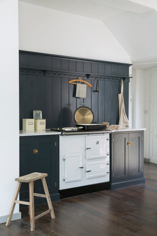 Klassische Küche mit Schrankfronten im Shaker-Stil, blauen Schränken, Marmor-Arbeitsplatte, weißen Elektrogeräten und dunklem Holzboden in London