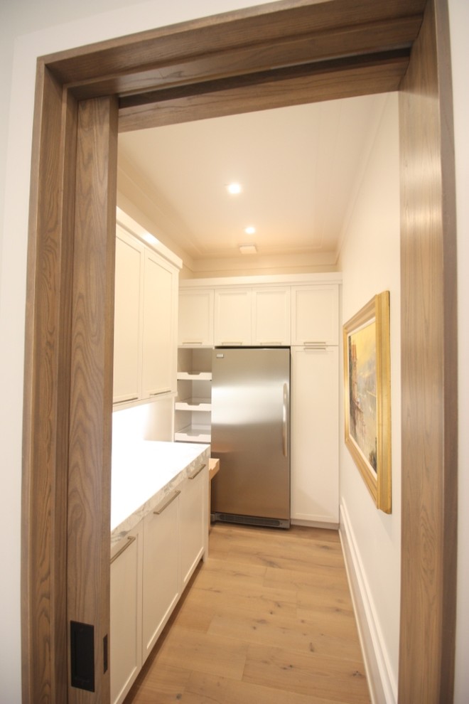 Idéer för att renovera ett mellanstort funkis grå linjärt grått kök och matrum, med luckor med infälld panel, vita skåp, marmorbänkskiva, grått stänkskydd, stänkskydd i sten, rostfria vitvaror, mörkt trägolv, en köksö och brunt golv