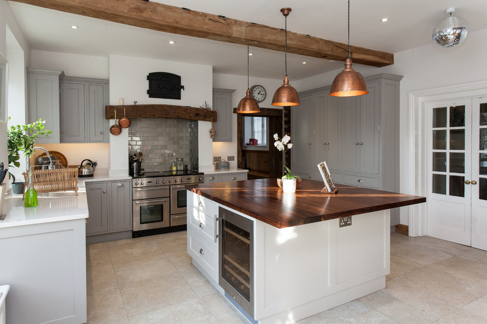Country Küche mit Schrankfronten im Shaker-Stil, grauen Schränken, Küchenrückwand in Grau, Rückwand aus Metrofliesen, Travertin und Kücheninsel in Hampshire