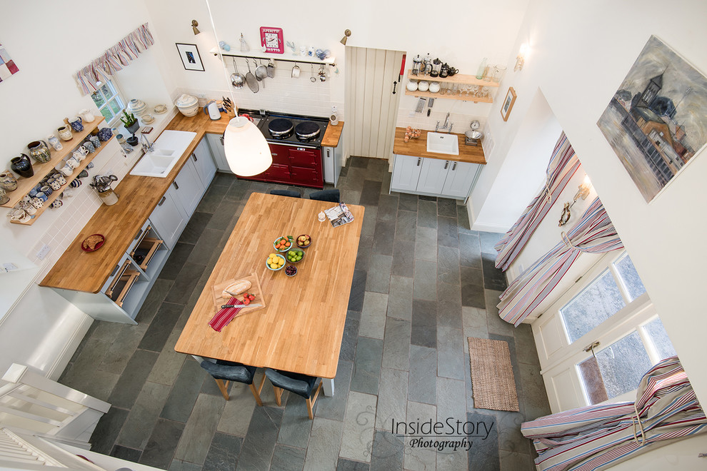 Photo of a large country l-shaped enclosed kitchen in Other with a built-in sink, shaker cabinets, blue cabinets, wood worktops, white splashback, ceramic splashback, coloured appliances, slate flooring and an island.
