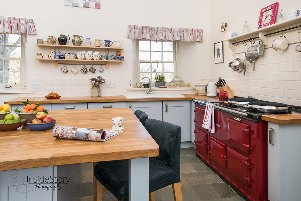 Inspiration for a large farmhouse l-shaped enclosed kitchen in Other with a built-in sink, shaker cabinets, blue cabinets, wood worktops, white splashback, ceramic splashback, coloured appliances, slate flooring and an island.