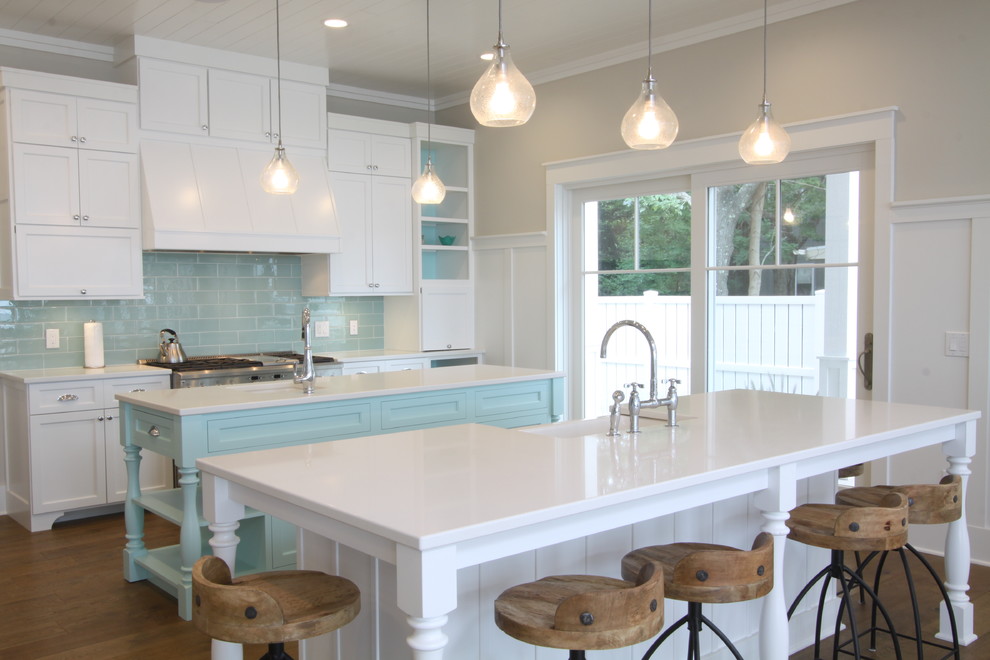 Large beach style l-shaped medium tone wood floor and brown floor open concept kitchen photo in Grand Rapids with an undermount sink, shaker cabinets, white cabinets, quartz countertops, blue backsplash, subway tile backsplash, stainless steel appliances and two islands