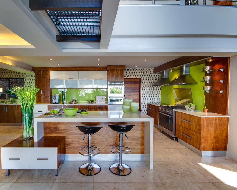 This is an example of a contemporary kitchen with flat-panel cabinets, green splashback, glass sheet splashback and medium wood cabinets.