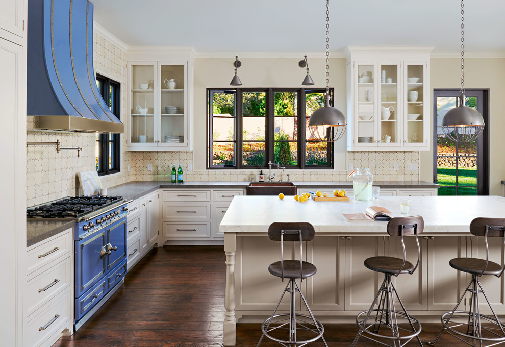Photo of a large traditional kitchen/diner in San Francisco with glass-front cabinets, coloured appliances, dark hardwood flooring, white cabinets, marble worktops, multi-coloured splashback, ceramic splashback and an island.