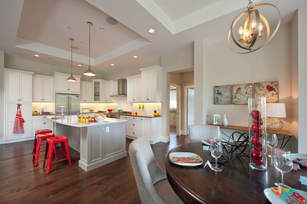 Trendy eat-in kitchen photo in Vancouver with stainless steel appliances, recessed-panel cabinets, white cabinets and white backsplash