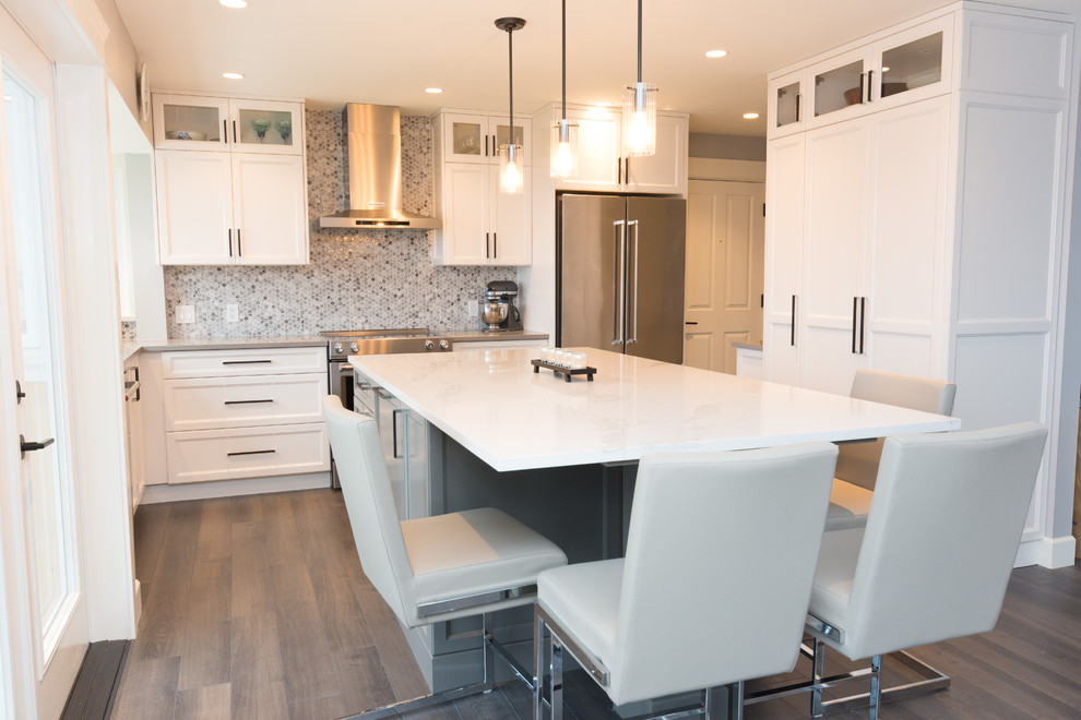 Photo of a medium sized traditional l-shaped open plan kitchen in Vancouver with shaker cabinets, white cabinets, engineered stone countertops, mosaic tiled splashback, stainless steel appliances, an island, brown floors, a submerged sink, multi-coloured splashback, dark hardwood flooring and grey worktops.