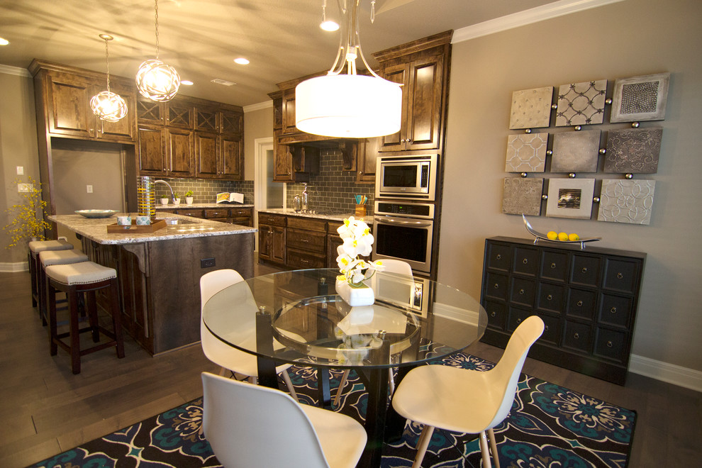 Mid-sized elegant l-shaped medium tone wood floor open concept kitchen photo in Kansas City with a single-bowl sink, raised-panel cabinets, medium tone wood cabinets, granite countertops, gray backsplash, glass tile backsplash, stainless steel appliances and an island