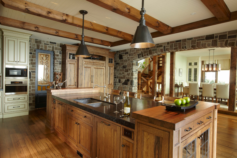 Photo of a large rustic enclosed kitchen in Toronto with wood worktops, a double-bowl sink, recessed-panel cabinets, medium wood cabinets, stainless steel appliances, medium hardwood flooring and an island.