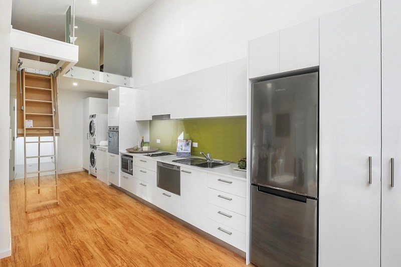 Small traditional galley kitchen/diner in Central Coast with a double-bowl sink, flat-panel cabinets, white cabinets, composite countertops, green splashback, glass sheet splashback, stainless steel appliances, vinyl flooring and no island.