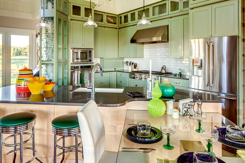 Eat-in kitchen - large country single-wall dark wood floor eat-in kitchen idea in Denver with a farmhouse sink, shaker cabinets, green cabinets, solid surface countertops, white backsplash, ceramic backsplash, stainless steel appliances and an island