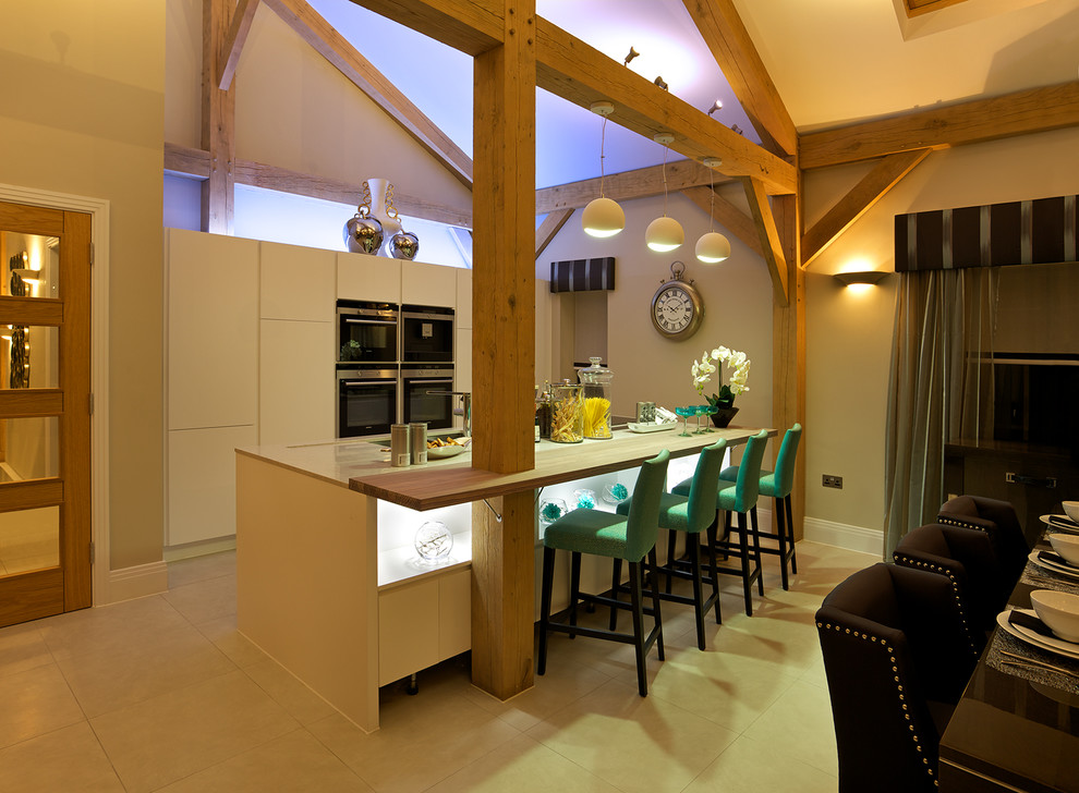 Foto på ett funkis parallellkök, med släta luckor, rostfria vitvaror, klinkergolv i porslin och en köksö