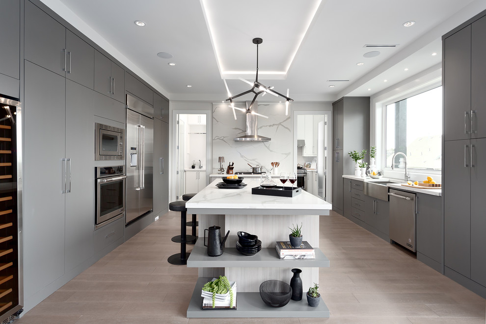 Moderne Küche in U-Form mit Landhausspüle, flächenbündigen Schrankfronten, grauen Schränken, Küchengeräten aus Edelstahl, Kücheninsel, beigem Boden und weißer Arbeitsplatte in Vancouver